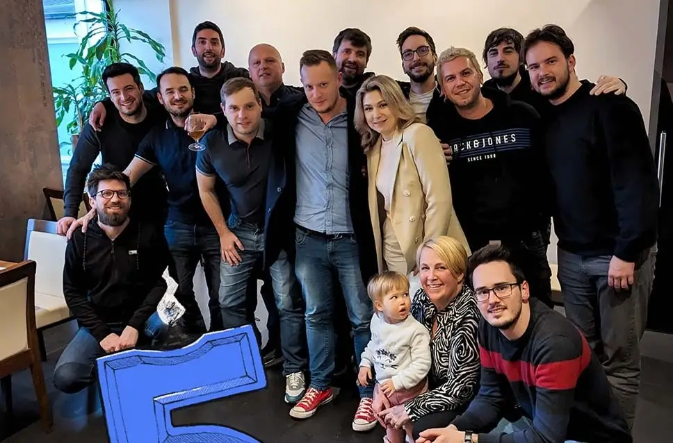 Skupinska fotografija ekipe agencije Kokos ob praznovanju v pisarni.